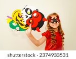 Small photo of Unique child. Halloween. Child in Halloween carnival mask. The child made handmade felt masks for Halloween. Girl prepared for Halloween celebration. Bat, pumpkin, witch, skull and devil mask