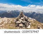 Small photo of Carin rock sculpture and mountains with white snow in background.