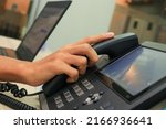 Small photo of Close-up IP phone on the work desk, The human hand lifted the telephone placed on the table, Hang up the telephone cord placed on the work desk.