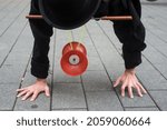 Closeup of man balacing on hands playing with diabolo in the street