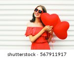 Portrait pretty happy smiling woman in red dress and sunglasses with air balloons heart shape over white background