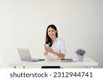 A happy and smiling young Asian businesswoman using her smartphone at her desk. isolated white studio background 