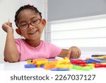 Small photo of 4-year-old brunette Latina girl with autism spectrum disorder ASD like Asperger, Rett and Heller draws at a desk, plays with colors alone antisocial