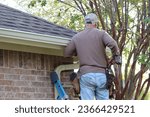 Small photo of Installing roof gutters; Workers Attaching Aluminum Rain Gutter and Down Spout; Contractor installing gutters on a residential building
