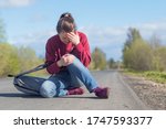 Small photo of Upset, frightened girl fell on the road and cry in pain. Dangerous situation on the street. Accident with female. Car is going to bring down a woman. Person is sitting on asphalt, got injured.