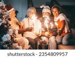 Happy family group of senior parents and middle aged son with wife celebrating Christmas holidays and new year together at home. Happy lifestyle for mature retirees, party lights