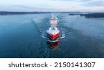 Small photo of LNG powered oil and chemical tanker making way ahead in Finnish archipelago during winter morning sunrise. Haze in the air and sea surface covered in light ice floes. Aerial front view