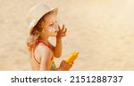 Small photo of Skin care. Safe protection from the sun. Sunscreen for children. The child holds a bottle of moisturizing Sunscreen in his hands and puts a protective layer on his face.