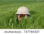 Little Boy with Binoculars and safari Hat, laying in the grass searching for Knowledge