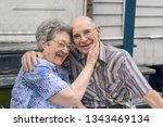 An elderly couple is sitting down on a May afternoon in Delcambre, Louisiana.  Two caucasian senior citizens are embracing each other. A marriage of an Octogenarian and Nonagenarian laughing in love.