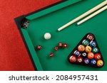 Billiard`s balls and red dices laying together on a green pool table. Billiard or  pool balls, children's toy.