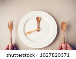 white plate with spoon and fork, Intermittent fasting concept, ketogenic diet, weight loss,  food crisis, restaurant and cafe reopening post covid-19 coronavirus pandemic