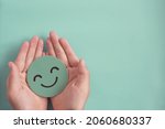 Hands holding green happy smile face , good feedback rating,positive customer review, experience, satisfaction survey ,mental health assessment, child wellness,world mental health day, Compliment Day