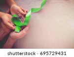 Adult and child hands holding Lime Green Ribbon, children Mental health awareness and organ donation, world mental health day, world kidney day