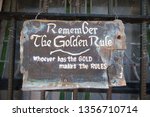 Small photo of Old miner's proverb written on a rustic sign: "Remember the Golden Rule whoever has the gold makes the rules"