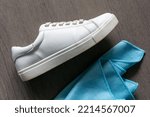 A white sneaker next to a cleaning cloth