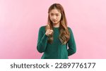 Small photo of Young women forefinger pointing with dissatisfaction and angry face isolated on pink background.