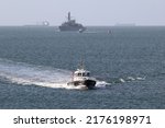 Small photo of PORTSMOUTH, UK – 9TH JUN 2022: The launch SD SOLENT RACER speeds back into port after taking the Admiralty pilot to the warship HMS PORTLAND, seen astern