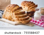 Fresh homemade  baked bread and sliced bread with milk on rustic white wooden table