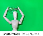 Small photo of Mannequin Wood Figure carrying an incandescent light bulb. New idea concept. green screen