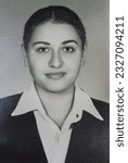 Small photo of Old black and white photograph on photographic paper from the 80s. Example of a passport photo. Young female model with a white background. An example of a photograph of a degree certificate