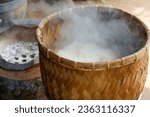 Small photo of steaming sticky rice on earthen steamer, sticky rice cooking on charcoal stove. Sticky rice is also known as glutinous rice and is widely popular among many Asian cuisines.