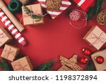 Christmas background with gift boxes, clews of rope, paper's rools and decorations on red. Preparation for holidays. Top view with copy space.