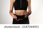 Small photo of A woman in a sports uniform holds a measuring tape in her hands - constrained by sports. High quality photo