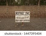Small photo of Sachsenhausen-Oranienburg, Germany - 7 July, 2019: Barbed fence with Neutral Zone table in Sachsenhausen Concentration Camp. This sign says You will be shot without warning, upon entering of this zone
