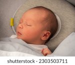 Small photo of A baby boy sleeping on the bed, an infant sleeps, Plagiocephaly Pillow, flat head pillow