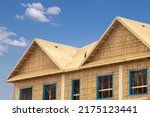 Small photo of A residential construction project showing plywood roof and dormer sheathing and oriented strand board or chip board sheathing on the exterior walls