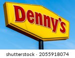 Small photo of Port Huron, MI USA - September 11, 2021: Horizontal, medium closeup of "Denny's" casual dining restaurant chain's free standing brand and logo signage on a blue sky, sunny day.