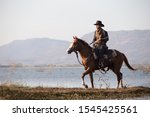 Cowboy Riding Horse In Lake...