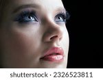 Portrait of young female face. Woman with lilac beauty eyes makeup. Girl with perfect skin and purple smoky eyes eye shadows.