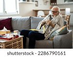 Small photo of Sick and depressed older man is having high temperature and using handkerchiefs in the bed, trying to override the sickness. Senior man is fighting with the sickness and feeling desperate.