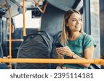 Small photo of Cheerful woman with cell phone in public transportation. Smiling young woman with cell phone in public transportation. Woman uses mobile app while riding commuter train