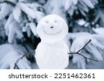 Smiling snowman. Makingsnowman in the forest from the first snow. Snowy winter, coniferous trees covered with snow. Portrait of snowman.