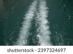 Small photo of The trace of a ship on the water. A plume on the water from a motor boat. The trace of a twin-engine boat on the water. A trace on the water from above the ship.