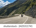Two bikers riding on the winding Grimsel Pass road, Obergoms, Canton of Valais, Switzerland