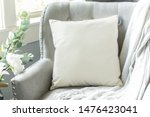 Off white throw pillow on a soft grey chair in a formal setting