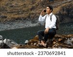 Small photo of A photo of a Caucasian student peasant boy using a smartphone during advertising in a park, Quechua native man with cell phone, lifestyle, communication