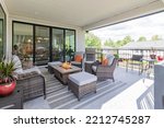 Small photo of A luxurious spacious deck with stylish patio furniture with a fire pit table heater and barbecue grill.