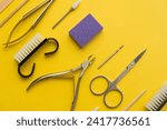 Small photo of Professional manicure tools on yellow background. Manicure set. Top view. Cuticle pusher, cuticle trimmer and purpose scissor. Set of manicure and pedicure tools and cosmetics with space