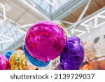Composition of purple, blue, yellow, pink balloons with helium. Foil balloons in the shape of a circle. inflated balloon.The concept of decorating a room with helium balloons for holidays or birthdays