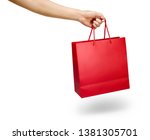 Hand holding a red color shopping bag isolated on white