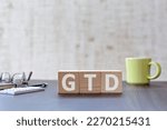 There is wood cube with the word GTD. It is an acronym for Getting Things Done an eye-catching image.