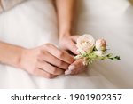 Close up bride holding buttonhole in hands