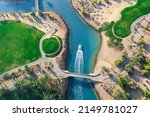 Bird eye view of the golf course with small boat crossing lagoons at tourists town El Gouna in The Red Sea, Egypt 