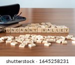 Small photo of uncanny valley concept represented by wooden letter tiles