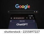 Small photo of ChatGPT chat bot page seen on smartphone and laptop display with blurred GOOGLE search page. AI chatbot vs search engine. Concept. Stafford, United Kingdom, January 29, 2023